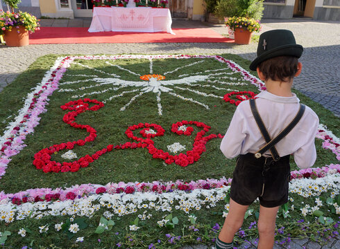 Ein Bub vor dem Fronleichnamsblumenteppüich auf dem Schrannenplatz in Füssen.