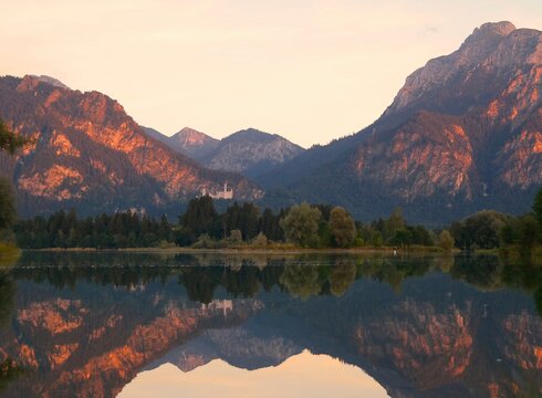Zur Website der Forggensee-Schifffahrt Das Bild zeigt den Blick über den Forggensee auf Sch.loss Neuschwanstein und die benachbarten Alpengipfel bei einer Abendfahrt mit der Forggensee-Schifffahrt.