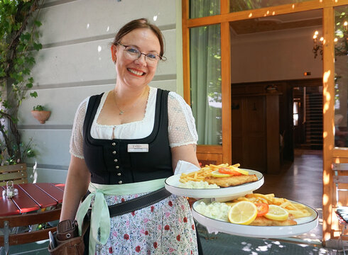 Bedienung serviert im Biergarten des Hotel Hirsch in Füssen