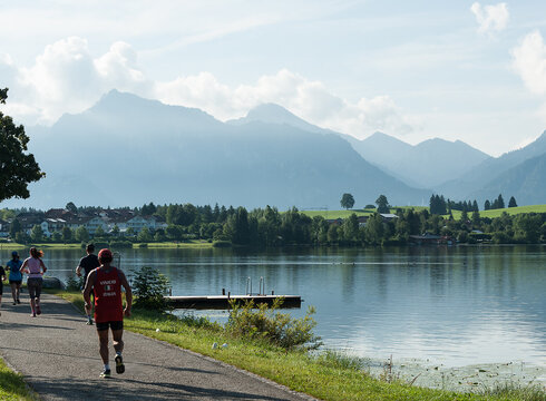 Zur Veranstaltungswebsite Königsschlösser-Marathonteilnehmer*innen am Hopfensee bei Füssen
