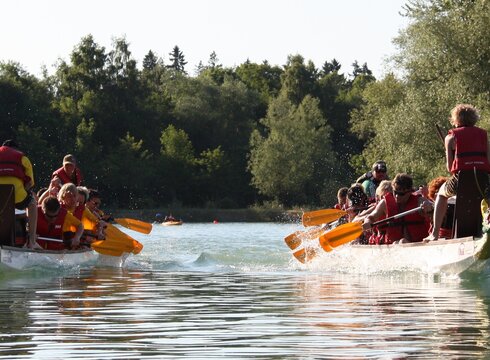 Zur Veranstaltungswebsite Zwei Teams beim Drachenbootrennen auf dem Forggensee.