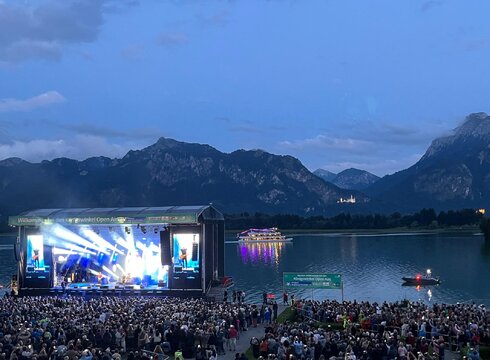 Zur Veranstaltungswebsite Das Foto zeigt die Seebühne der Königswinkel Open Airs am Forggenseeufer mit Publikum.