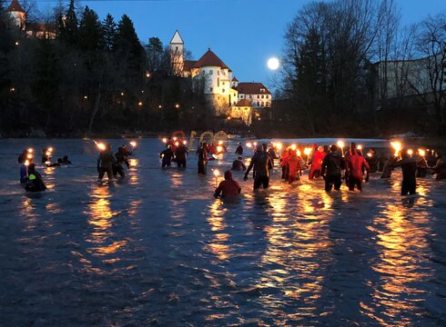 Fackelschwimmer im Lech in der Abenddämmerung