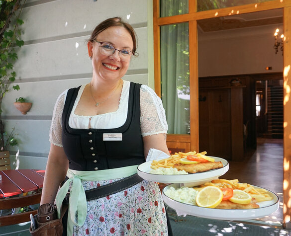 Bedienung serviert im Biergarten des Hotel Hirsch in Füssen