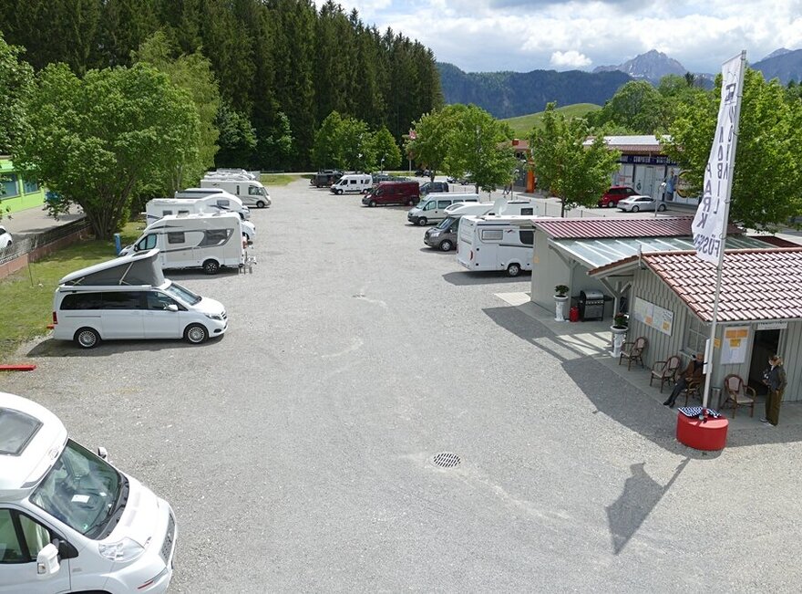 Das Bild zeigt den Wohnmobilpark Füssen mit einigen Wohnmobilen und den Tannheimer Alpen im Hintergrund