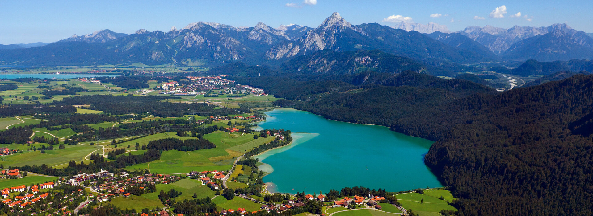 Panoramaaufnahme mit dem Weißensee, Füssen und dem Ammergebirge im Hintergrund